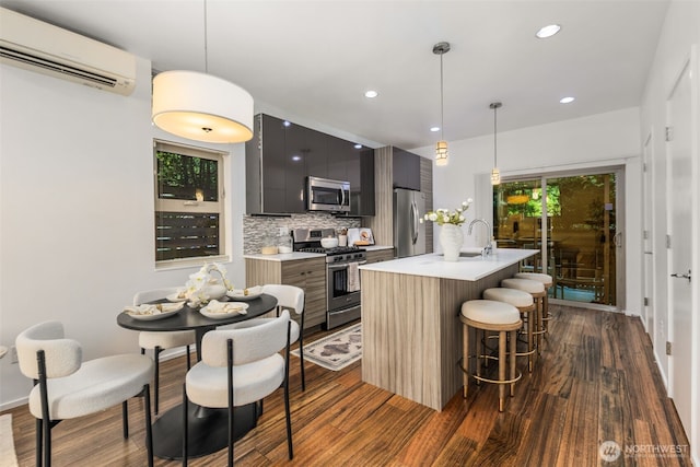 721 26th Ave S Unit B, Seattle, WA 98144 - kitchen with appliances with stainless steel finishes, modern cabinets, a wall mounted AC, light countertops, and dark wood-style flooring