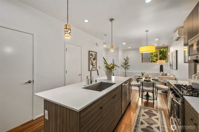 721 26th Ave S Unit B, Seattle, WA 98144 - kitchen with appliances with stainless steel finishes, dark wood-type flooring, light countertops, modern cabinets, and a kitchen island with sink
