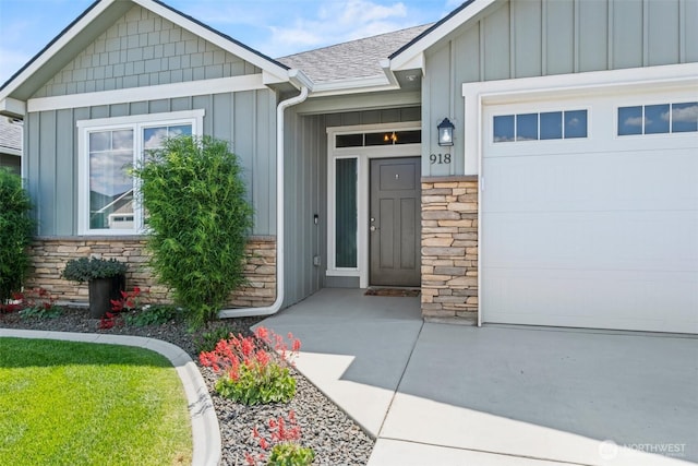 918 N M Loop Dr SW, Quincy, WA 98848 - view of exterior entry featuring board and batten siding, an attached garage, stone siding, and a shingled roof