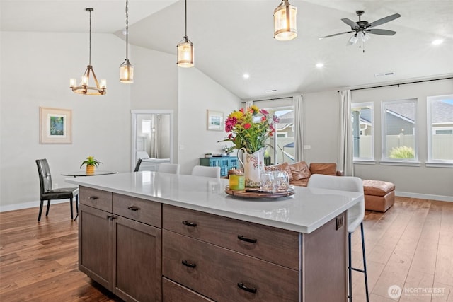 918 N M Loop Dr SW, Quincy, WA 98848 - kitchen with open floor plan, hardwood / wood-style floors, a kitchen bar, ceiling fan, and light countertops