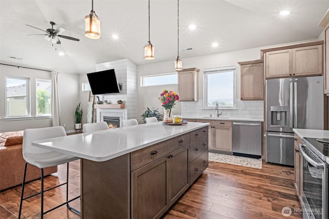 918 N M Loop Dr SW, Quincy, WA 98848 - kitchen with open floor plan, appliances with stainless steel finishes, backsplash, wood-type flooring, and light countertops