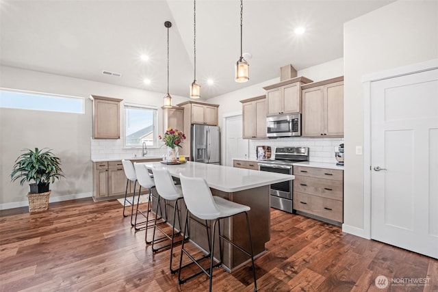918 N M Loop Dr SW, Quincy, WA 98848 - kitchen featuring appliances with stainless steel finishes, a breakfast bar area, a center island, tasteful backsplash, and light countertops