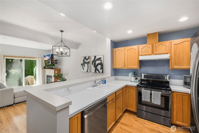 418 17th St SE Unit 5C, Auburn, WA 98002 - kitchen with appliances with stainless steel finishes, under cabinet range hood, a peninsula, light wood-style floors, and recessed lighting