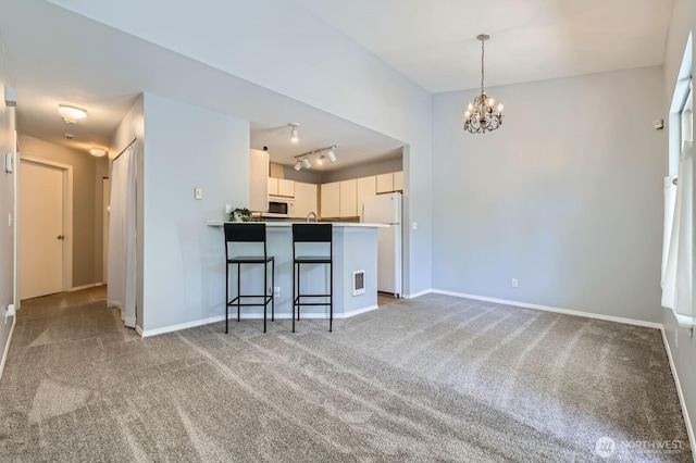 9210 Market Pl Unit F202, Lake Stevens, WA 98258 - kitchen with carpet, a chandelier, white appliances, and a peninsula