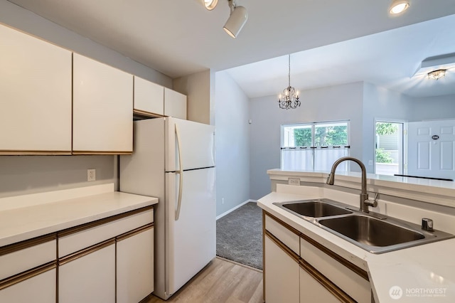 9210 Market Pl Unit F202, Lake Stevens, WA 98258 - kitchen featuring white cabinets, light countertops, light wood-type flooring, freestanding refrigerator, and decorative light fixtures