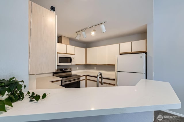 9210 Market Pl Unit F202, Lake Stevens, WA 98258 - kitchen featuring white appliances, light countertops, track lighting, and a peninsula