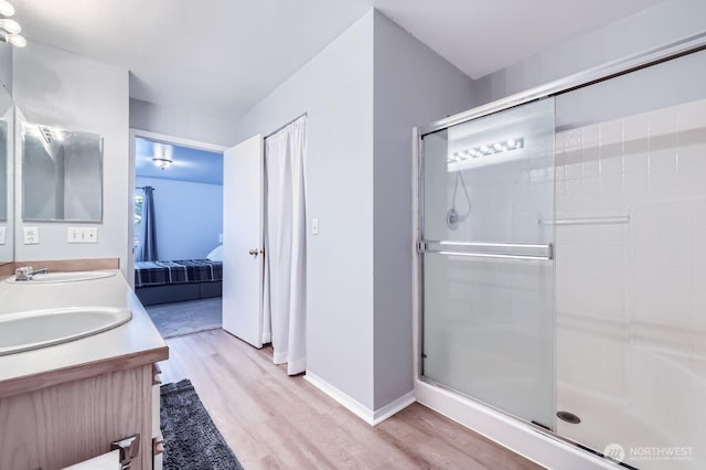 9210 Market Pl Unit F202, Lake Stevens, WA 98258 - full bath with wood finished floors, connected bathroom, a shower stall, and double vanity