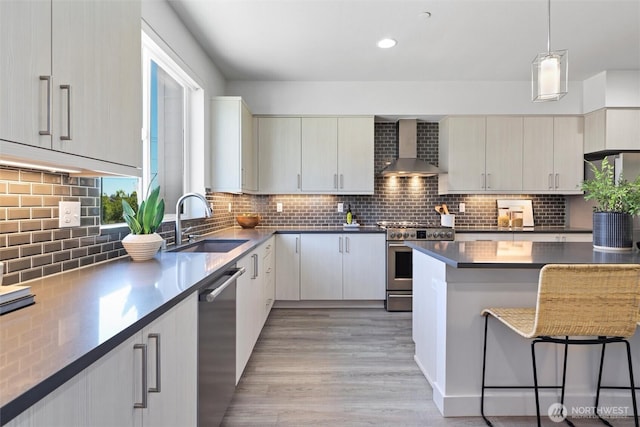 17905 35th Ave SE Unit C3, Bothell, WA 98012 - kitchen with wall chimney range hood, appliances with stainless steel finishes, light wood-style floors, tasteful backsplash, and recessed lighting