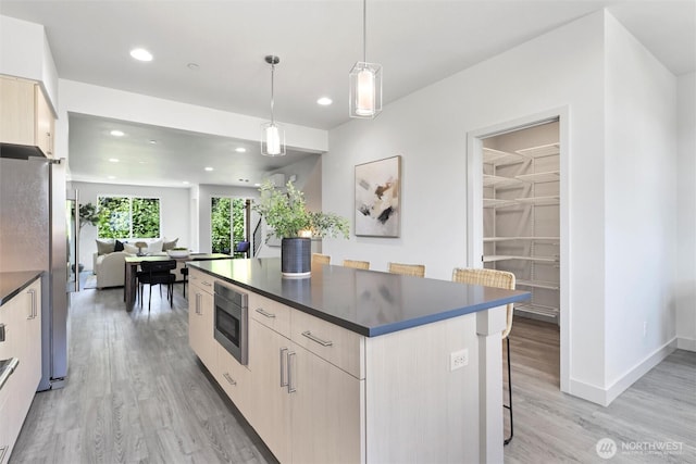 17905 35th Ave SE Unit C3, Bothell, WA 98012 - kitchen featuring modern cabinets, dark countertops, stainless steel appliances, light wood-style floors, and a kitchen island