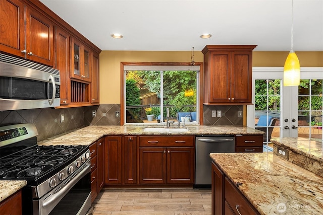 15214 102nd Ave NE, Bothell, WA 98011 - kitchen featuring stainless steel appliances, light wood-style flooring, light stone counters, backsplash, and glass insert cabinets