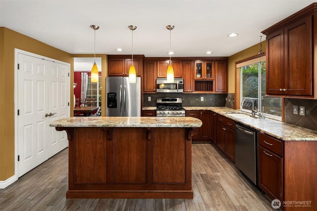 15214 102nd Ave NE, Bothell, WA 98011 - kitchen featuring appliances with stainless steel finishes, wood finished floors, tasteful backsplash, light stone countertops, and recessed lighting