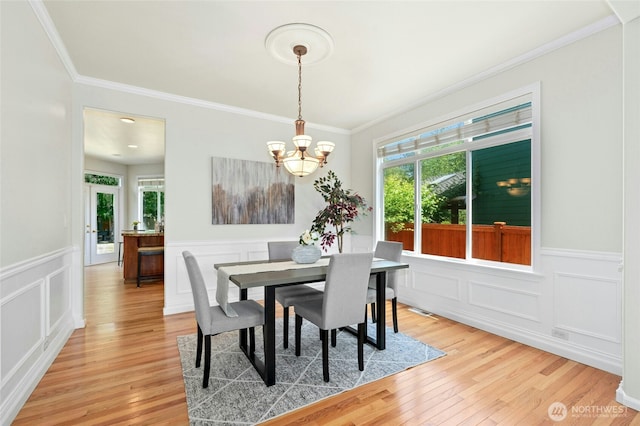3303 174th Pl SE, Bothell, WA 98012 - dining room featuring a chandelier, light wood finished floors, ornamental molding, wainscoting, and a decorative wall
