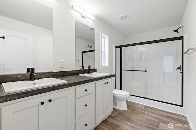 25405 36th Ave E, Spanaway, WA 98387 - bathroom featuring a stall shower, double vanity, and wood finished floors