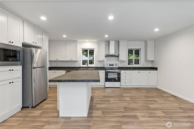 25405 36th Ave E, Spanaway, WA 98387 - kitchen featuring stainless steel appliances, wall chimney range hood, recessed lighting, healthy amount of natural light, and dark countertops