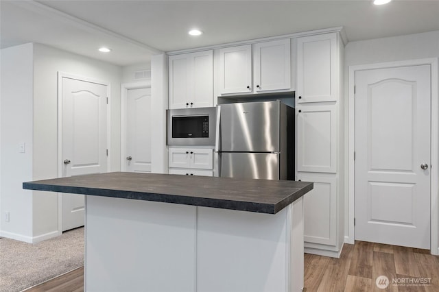 25405 36th Ave E, Spanaway, WA 98387 - kitchen with appliances with stainless steel finishes, recessed lighting, light wood-style floors, white cabinets, and a center island