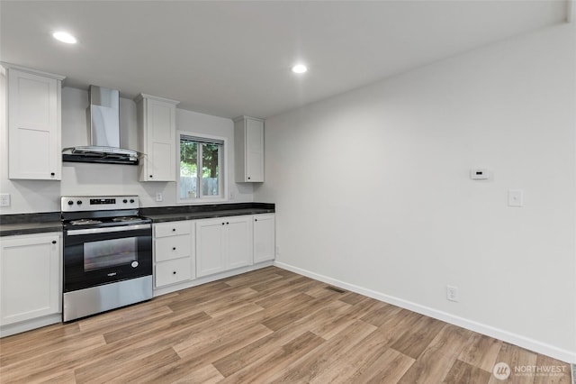 25405 36th Ave E, Spanaway, WA 98387 - kitchen featuring stainless steel range with electric stovetop, wall chimney range hood, dark countertops, light wood-style flooring, and recessed lighting