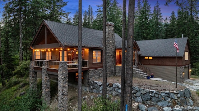 16060 Telemark Ln, Leavenworth, WA 98826 - view of front facade with stone siding, a chimney, and a shingled roof