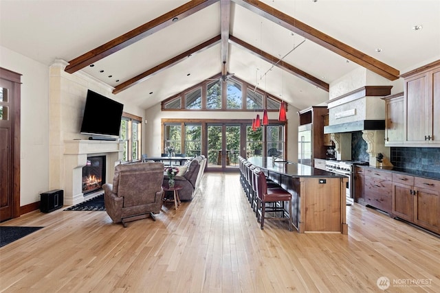 16060 Telemark Ln, Leavenworth, WA 98826 - living area featuring a glass covered fireplace, beam ceiling, light wood finished floors, and high vaulted ceiling