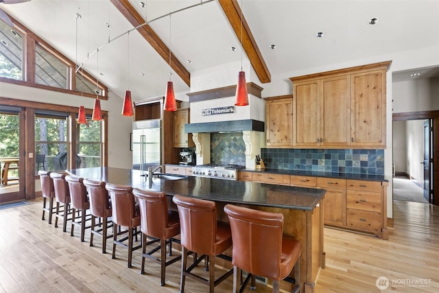 16060 Telemark Ln, Leavenworth, WA 98826 - kitchen featuring built in fridge, beamed ceiling, light wood-style flooring, dark countertops, and tasteful backsplash