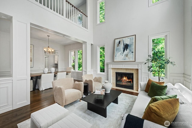 4935 163rd Pl SE, Bellevue, WA 98006 - living area with a decorative wall, dark wood-style floors, a chandelier, a fireplace, and a towering ceiling