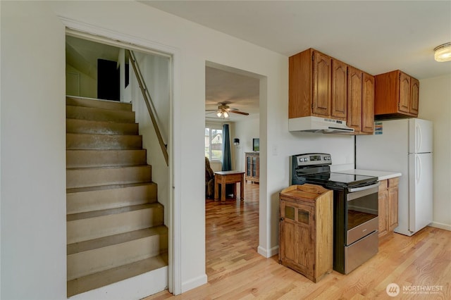 4637 N Visscher St, Tacoma, WA 98407 - kitchen with stainless steel range with electric cooktop, under cabinet range hood, light wood-type flooring, ceiling fan, and brown cabinetry