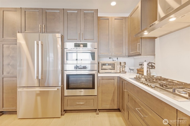 4907 Main St Unit 207, Tacoma, WA 98407 - kitchen featuring stainless steel appliances, extractor fan, light countertops, recessed lighting, and light wood-type flooring