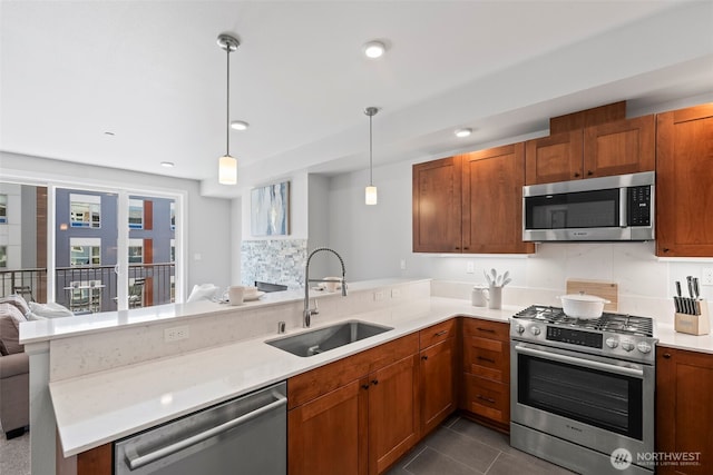 4961 Main St Unit 719, Tacoma, WA 98407 - kitchen with appliances with stainless steel finishes, a peninsula, open floor plan, light countertops, and brown cabinetry