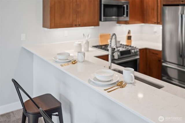 4961 Main St Unit 719, Tacoma, WA 98407 - kitchen with appliances with stainless steel finishes, brown cabinetry, and a kitchen breakfast bar