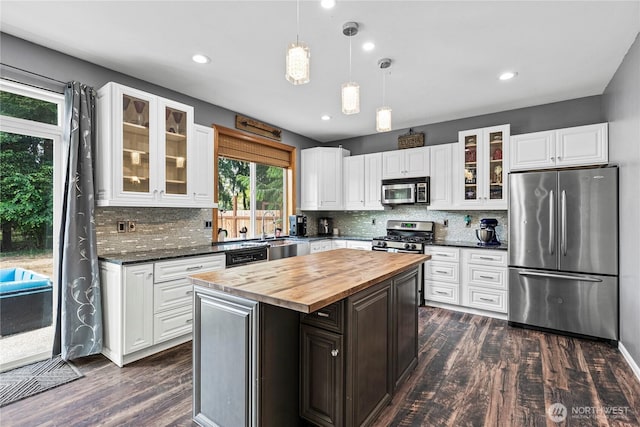 20523 193rd Avenue Ct E, Orting, WA 98360 - kitchen with appliances with stainless steel finishes, wooden counters, dark wood-type flooring, white cabinets, and backsplash