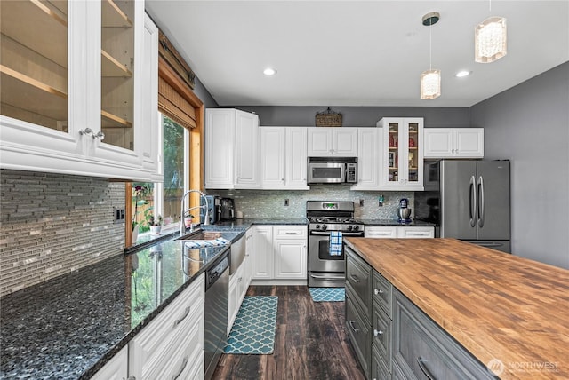 20523 193rd Avenue Ct E, Orting, WA 98360 - kitchen featuring stainless steel appliances, butcher block countertops, dark wood finished floors, white cabinets, and decorative backsplash