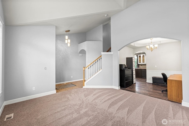 20523 193rd Avenue Ct E, Orting, WA 98360 - spare room featuring arched walkways, dark colored carpet, high vaulted ceiling, stairway, and a chandelier