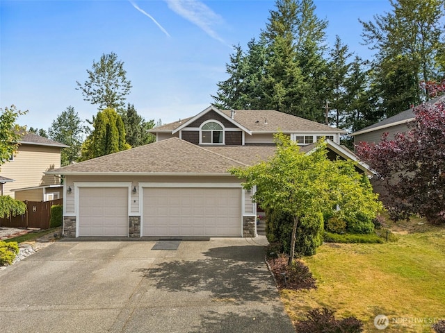 20523 193rd Avenue Ct E, Orting, WA 98360 - view of front of property featuring stone siding, asphalt driveway, an attached garage, and roof with shingles