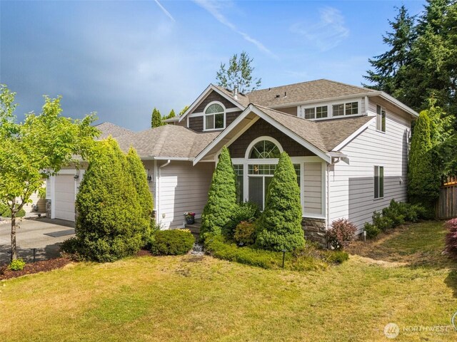 20523 193rd Avenue Ct E, Orting, WA 98360 - view of front of house featuring roof with shingles, a garage, and asphalt driveway