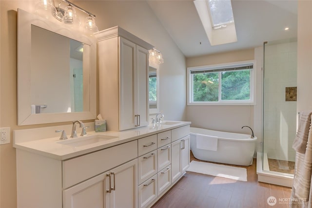 18915 SE 284th Ct, Kent, WA 98042 - full bath featuring a skylight, a freestanding bath, double vanity, wood finished floors, and tiled shower