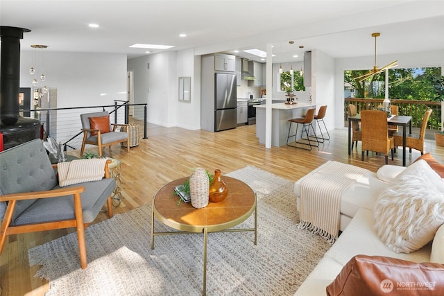 12569 37th Ave NE, Seattle, WA 98125 - living room featuring light wood-style floors, a wood stove, and recessed lighting