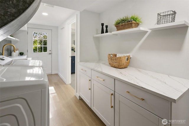 12569 37th Ave NE, Seattle, WA 98125 - laundry area featuring washing machine and dryer, light wood-style flooring, cabinet space, and recessed lighting