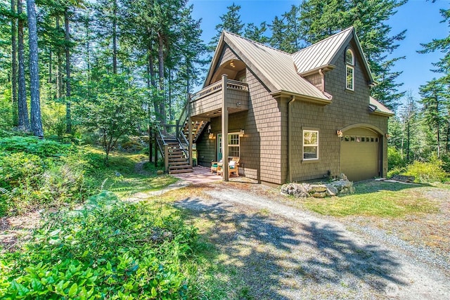87 Levon Ln, Orcas Island, WA 98243 - view of front of home with driveway, an attached garage, a standing seam roof, stairway, and a metal roof