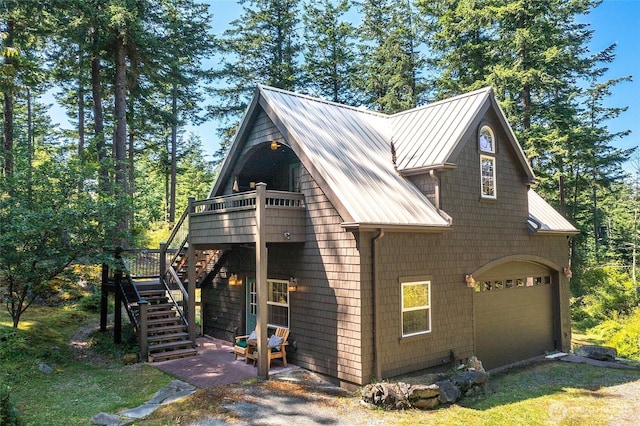 87 Levon Ln, Orcas Island, WA 98243 - view of property exterior featuring stairs, an attached garage, a metal roof, and a wooden deck