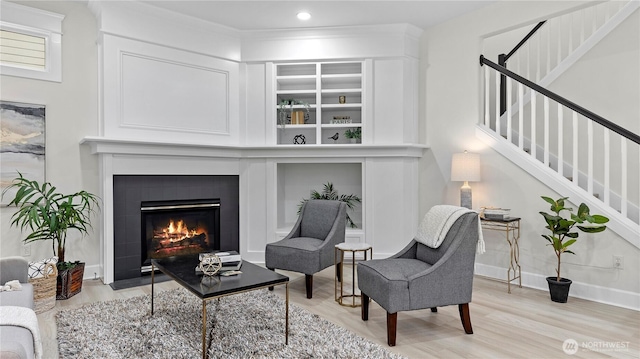 11832 158th Ave NE, Redmond, WA 98052 - living area with stairway, light wood-style floors, a fireplace with flush hearth, built in shelves, and recessed lighting