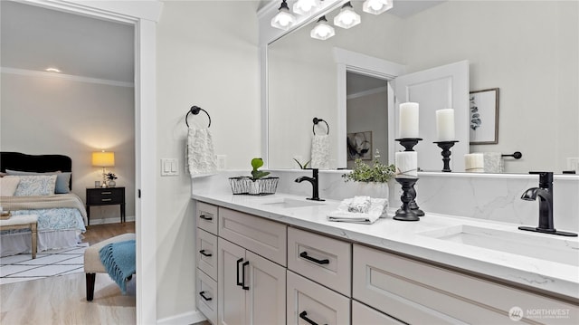11832 158th Ave NE, Redmond, WA 98052 - ensuite bathroom with double vanity, ornamental molding, and wood finished floors