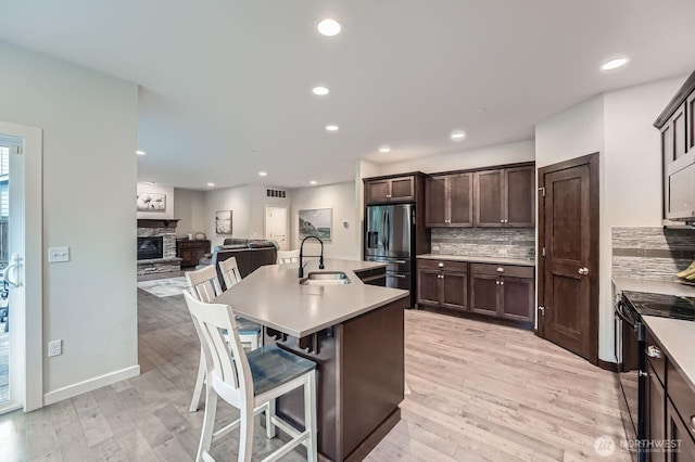 3592 SE 16th St, North Bend, WA 98045 - kitchen with stainless steel fridge with ice dispenser, black / electric stove, dark brown cabinetry, backsplash, and recessed lighting