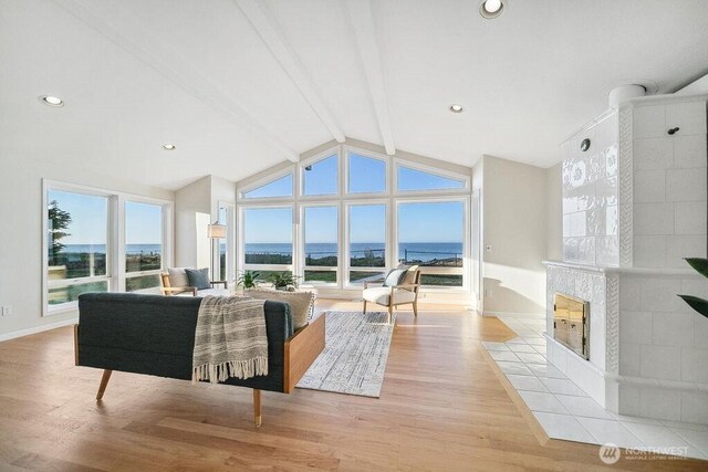 12 Jamestown Beach Ln, Sequim, WA 98382 - living room featuring wood finished floors, a tile fireplace, and a water view
