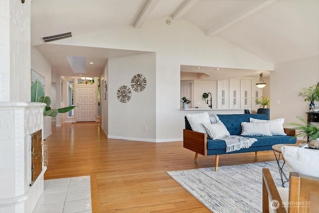 12 Jamestown Beach Ln, Sequim, WA 98382 - living room with light wood-type flooring, beam ceiling, high vaulted ceiling, and a tiled fireplace