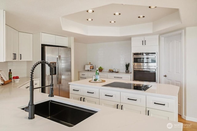 12 Jamestown Beach Ln, Sequim, WA 98382 - kitchen featuring stainless steel appliances, a raised ceiling, tasteful backsplash, recessed lighting, and white cabinets