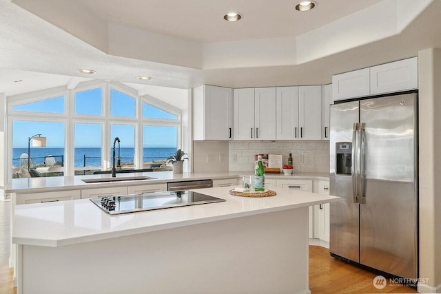 12 Jamestown Beach Ln, Sequim, WA 98382 - kitchen with stainless steel appliances, white cabinets, a water view, light wood finished floors, and recessed lighting