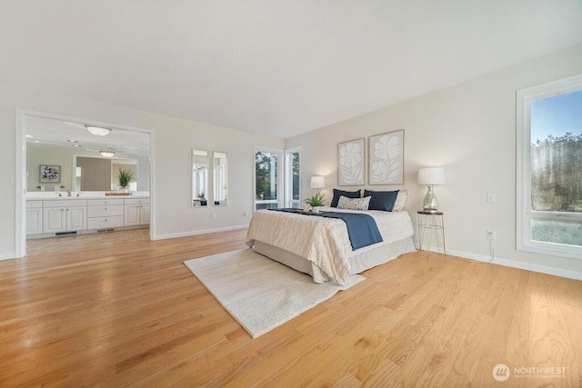 12 Jamestown Beach Ln, Sequim, WA 98382 - bedroom with light wood-type flooring, multiple windows, and ensuite bathroom