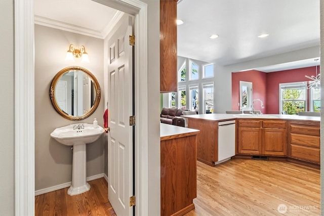 3819 Ridge Ct, Mount Vernon, WA 98274 - kitchen with dishwasher, ornamental molding, light wood-style flooring, brown cabinets, and light countertops