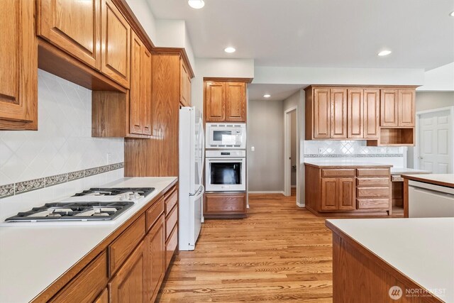 3819 Ridge Ct, Mount Vernon, WA 98274 - kitchen with white appliances, light wood finished floors, backsplash, recessed lighting, and light countertops
