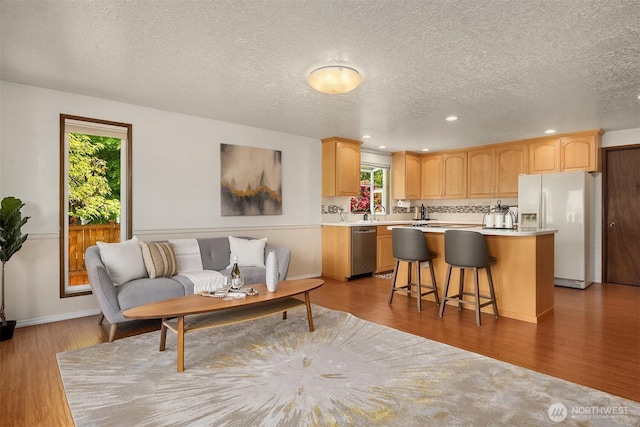 9119 185th Pl SW, Edmonds, WA 98026 - kitchen featuring white refrigerator with ice dispenser, a kitchen island, light countertops, plenty of natural light, and recessed lighting
