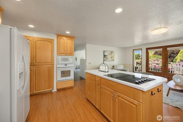 9119 185th Pl SW, Edmonds, WA 98026 - kitchen with white appliances, a textured ceiling, light wood-style flooring, light countertops, and recessed lighting